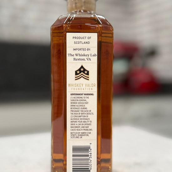 Bottle of whiskey with a label on a marble surface