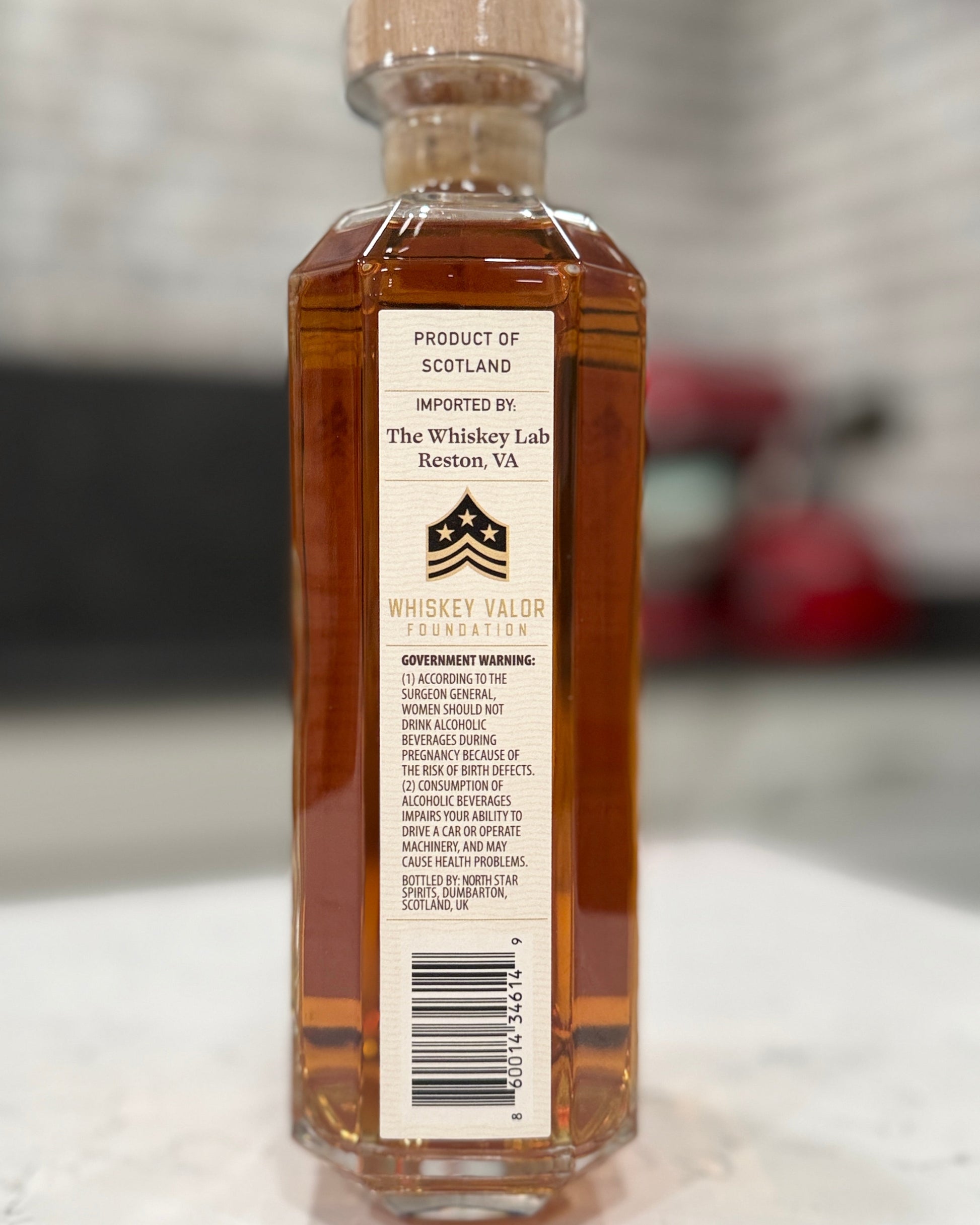 Bottle of whiskey with a label on a marble surface