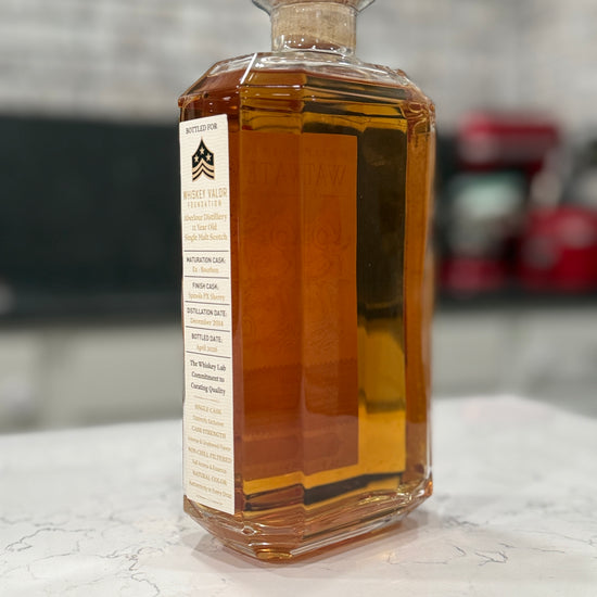 Bottle of amber liquid with a label on a marble surface