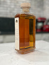 Bottle of amber liquid with a label on a marble surface