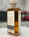 Bottle of Whispering Waters whiskey on a marble surface with a blurred background